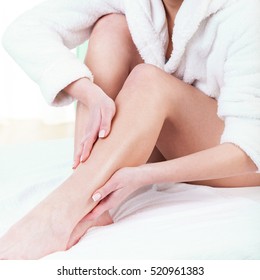 Woman Rubbing Lotion On Her Legs After Depilation