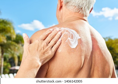 Woman Rubs Sunscreen On A Man's Back As Skin Protection In Summer