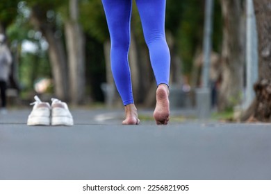 Woman runner is running barefoot without shoes to avoid bunion, achilles and other foot injuries as a result of narrow toe box from conventional sport shoes to build better muscle strength - Shutterstock ID 2256821905