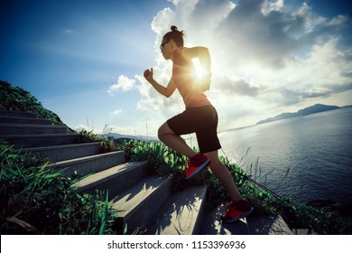 Woman runner running up on seaside mountain stairs