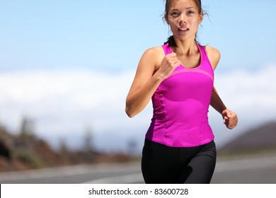 woman runner training for marathon. Female runner in sporty pink tank top jogging on mountain road. Beautiful young mixed race Asian Caucasian female fitness model outside. - Powered by Shutterstock