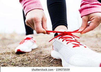 Woman Runner Tying Sport Shoes. Walking Or Running Legs, Autumn Adventure And Exercising Outdoors. Motivation And Inspiration Fitness Concept Outside.