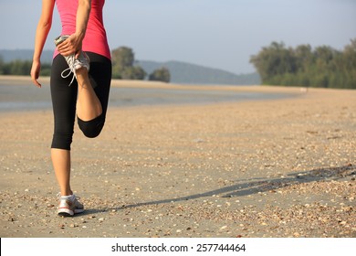 Woman Runner Warm Up Before Taking A Jogging On Beach