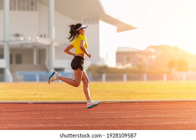 woman running during sunny morning on stadium track