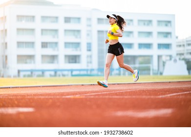 woman running during sunny morning on stadium track - Powered by Shutterstock