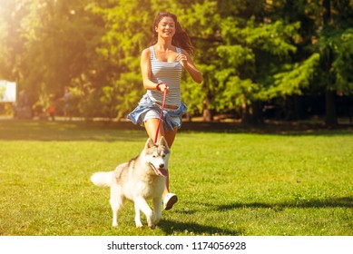 A Woman Running With Her Dog Outdoor