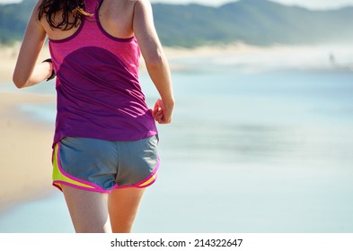 Woman running on beach, beautiful girl runner jogging outdoors, training for marathon, exercising and fitness concept 