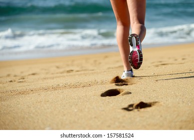 Woman Running On Beach. Sport Footwear, Sand Footprints And Legs Close Up. Runner Feet Detail.