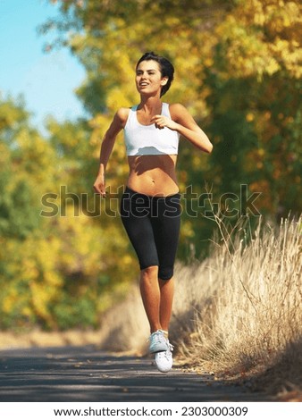 Woman is running on road, cardio and fitness outdoor in nature with healthy and active person. Sport, exercise and body training for marathon, young female runner workout for health with energy
