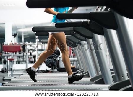 woman running on a treadmill in a fitness club, sport in the fitness club