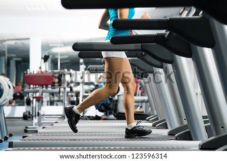 woman running on a treadmill in a fitness club, sport in the fitness club