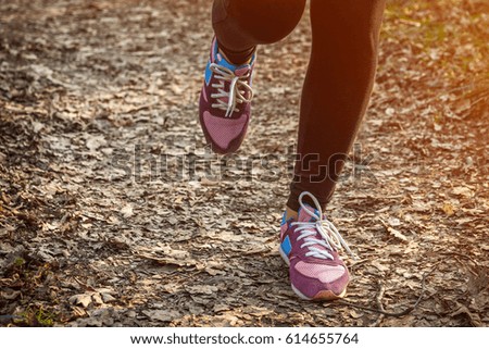 Woman running in spring forest at sunset