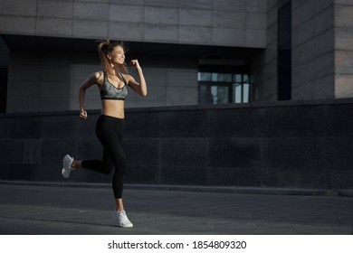 Woman Running Urban City Street Background Active Sporty Caucasian Female Morning Workout Healthy Lifestyle Concept. Athletic Person Dressed Sportswear Do Exercises Dark Tone Mood Corporate Building