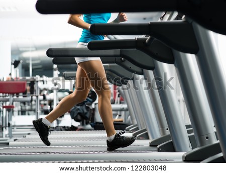 woman runs on a treadmill, exercise in the sport club