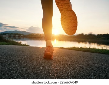 Woman runs in the park on autumn morning. Healthy lifestyle concept, people go in sports outdoors. Silhouette family at sunset. Fresh air. Health care, authenticity, sense of balance and calmness. - Shutterstock ID 2256607049
