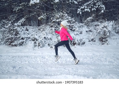 A Woman Runs In The Snow In The Winter Mountains. Sports, Fitness - Inspiration And Motivation. Woman Jogging Outdoors. High Quality Photo.