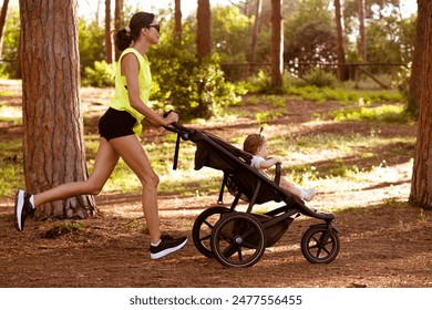 A woman runs with a stroller in the forest. - Powered by Shutterstock