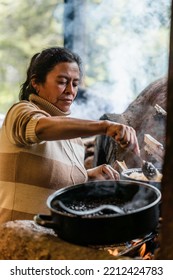 Woman From A Rural Community At A Traditional Wood-burning Stove .