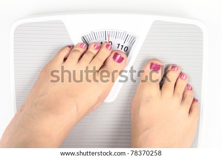 Woman' s feet on bathroom scale. Diet Concept
