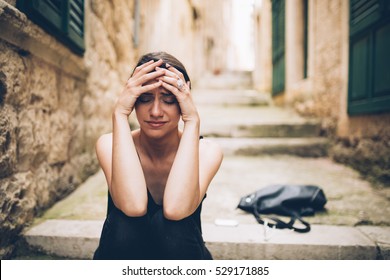 Woman with sad face crying.Sad expression,sad emotion,despair,sadness.Woman in emotional stress and pain.Woman sitting alone on the stairs, after a fight with a boyfriend.Relationship and love problem