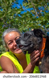 Woman In Safety Vest Walking Dogs In The Forest Of South France