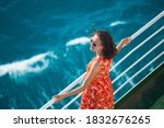 A woman is sailing on a cruise ship, a girl is standing near the fence on a ship and looking at the sea, traveling by ferry, a brunette in a summer dress admires the ocean.