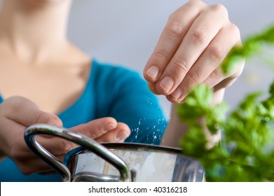 Woman Salting Water For Cooking