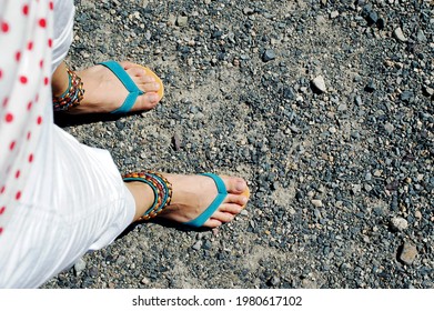 A Woman In Sandals Walking On A Cobbled Road