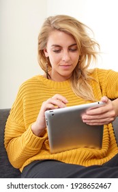 Woman Sat On A Sofa Using A Tablet