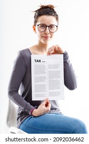 Woman Sat On A White Plastic Chair, Serene Showing A Tax Form With A Slight Sly Smile