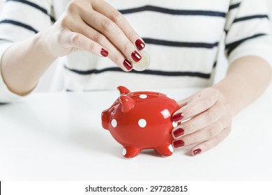 Woman Saving Money With Red Piggy Bank