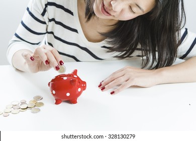 Woman Saving Money With Red Piggy Bank