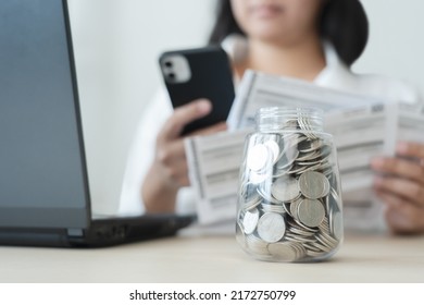 Woman Scan Bills To Make Online Payment Mobile Banking Conept. Working Hard To Save More Money Coins In Jar And Pay For The Bills.