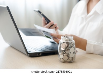 Woman Scan Bills To Make Online Payment Mobile Banking Conept. Working Hard To Save More Money Coins In Jar And Pay For The Bills.