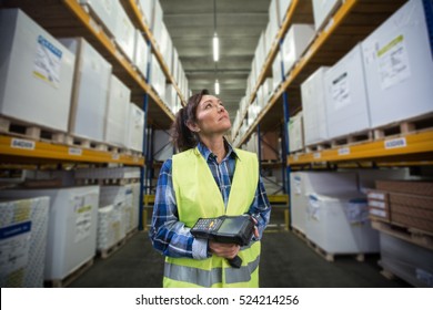 Woman with a scanner in her hands is checking inventory levels in a warehouse. First in first out, Last in last out, just in time delivery concept photo.