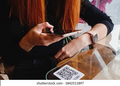Woman scanning the barcode qr code in restaurant or cafe
