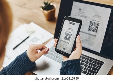 Woman scanning QR code from invoice to make payment using fast secure payment system and smartphone code reader. Business woman paying bills using express payment technology. Female using mobile phone