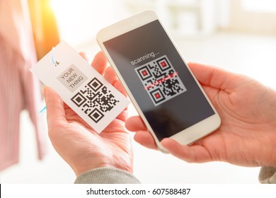 Woman Scanning QR Code From A Label In A Shop With Mobile Phone