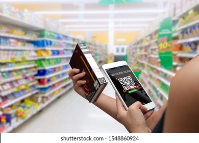 Woman Scanning QR Code For Product Details In Supermarket With Mobile Phone