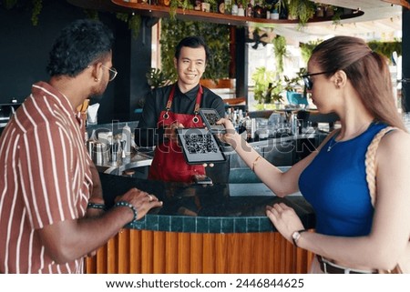 Woman scanning qr code when paying for order in restaurant