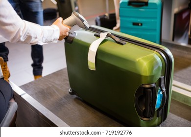 Woman Scanning Tag On Luggage At Airport Check-in