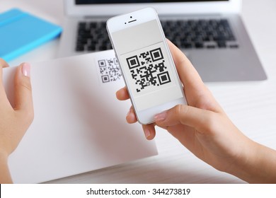 Woman scanning voucher code with mobile phone close up - Powered by Shutterstock