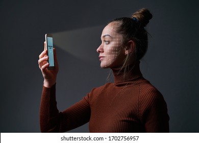 Woman Scans Face Using Facial Recognition System On Mobile Phone For Biometric Identification. Future High Tech Technology And Face Id   