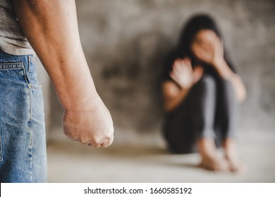Woman scaring and protection of Man beating up, beaten and raped sitting in the corner ; violence concept - Shutterstock ID 1660585192