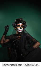 Woman In Scary Santa Muerte Costume Posing On Green Background