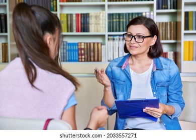 Woman school psychologist, teacher, social worker, mentor working with teenage girl - Powered by Shutterstock