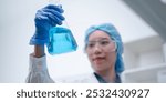 Woman scientist chemist holding laboratory blue liquid beaker test tube equipment for discovery analysis science chemical medicine development experiment technology biotechnology development