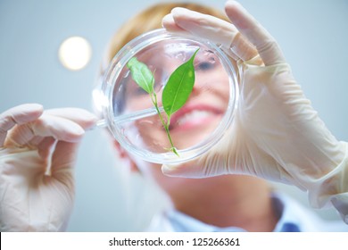 Woman scientist holding a test tube with plant - Powered by Shutterstock