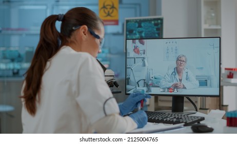 Woman scientist meeting with expert on online video conference, discussing about medical research for experiment. Chemistry worker using remote tele conference to talk to specialist.