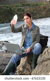 Woman Scientist Testing Quality Of Water In River